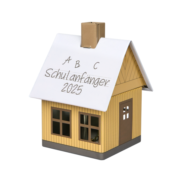 Das Original Crottendorfer Räucherhäuschen Schulanfänger 2025 ist ein kleines, gelbes Räucherhäuschen in Hausform mit weißem Dach, auf dem der handschriftliche Text „ABC Schulanfänger 2025“ steht und das über drei Fensterausschnitte und eine Tür auf der Vorderseite verfügt.