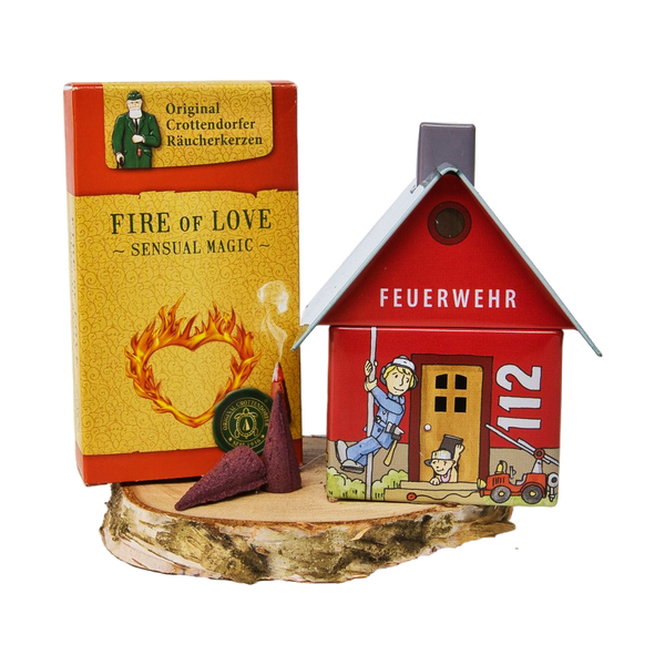 Das Geschenkset „Räucherhäuschen + Räucherkerzen“ von Original Crottendorfer Räucherkerzen enthält den Räucherhalter „Feuerwehr 112“, eine Schachtel „Fire of Love – Sensual Magic“ sowie Räucherkegel, die alle wunderschön auf einem Holzsockel arrangiert sind.