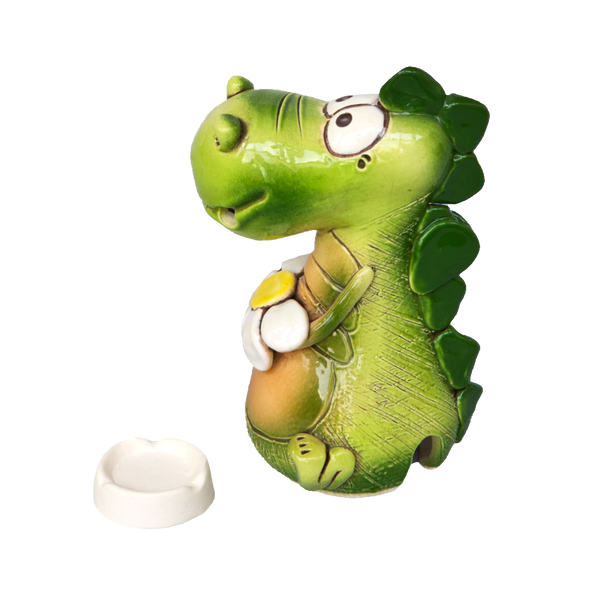 Der KU Räucherdrache mit Blume von Kurilin DECO ist eine kleine, handgefertigte Drachenfigur aus Keramik, die ein gelbes Ei hält und erstaunt nach oben blickt. Dazu gehört ein separater weißer, runder Teller, alles vor einem schlichten weißen Hintergrund.