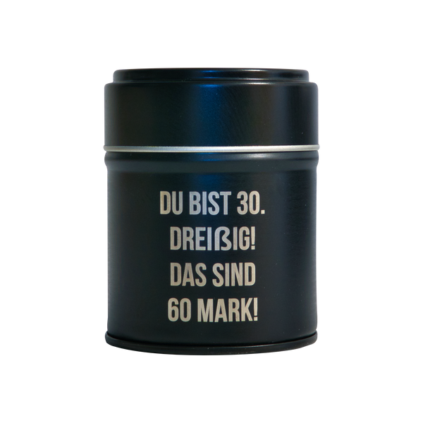 Das Räucherfass runder Geburtstag von Original Crottendorfer Räucherkerzen - eine schwarze Dose mit weißem Text "DU BIST 30. DREIßIG! DAS SIND 60 MARK!" - bringt klassischen Stil, ideal als tragbarer Räucherkerzenhalter. Auf einem schlichten schwarzen Hintergrund.