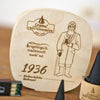 Die „Spanschachtel 1936“ von Original Crottendorfer Räucherkerzen verfügt über eine Holzplakette, auf der ein bärtiger Mann in einem Mantel mit einem Spazierstock eingraviert ist, begleitet von einem deutschen Text und der Jahreszahl 1936. Zusammen mit den kegelförmigen schwarzen Objekten ist dieses Set ein ideales Geschenkset für Sammler traditioneller Spanschachteln oder Liebhaber einzigartiger Räucherzubehörteile.