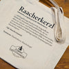 Ein beiger Stoffbeutel von Original Crottendorfer mit dem Aufdruck „Raacherkerzl Definition“ und Hausillustration – perfekt für Fans der Crottendorfer Räucherkerzen und der erzgebirgischen Räucherkultur.