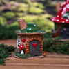 Das Räucherhaus „Waldromance“ von Original Crottendorfer ist ein kleines, dekoratives Räucherhaus mit einem grünen Dach, zarten Herzverzierungen, einer runden Tür und einem bezaubernden roten Pilz am Eingang. Dieses liebevoll aus Keramik handgefertigte Stück steht auf einem Holzsockel, umgeben von weichem Moos, und strahlt Charme und Verspieltheit aus. Im Hintergrund ist ein weiteres Häuschen mit rotem Dach zu sehen, das sanft aus dem Bild verschwindet.