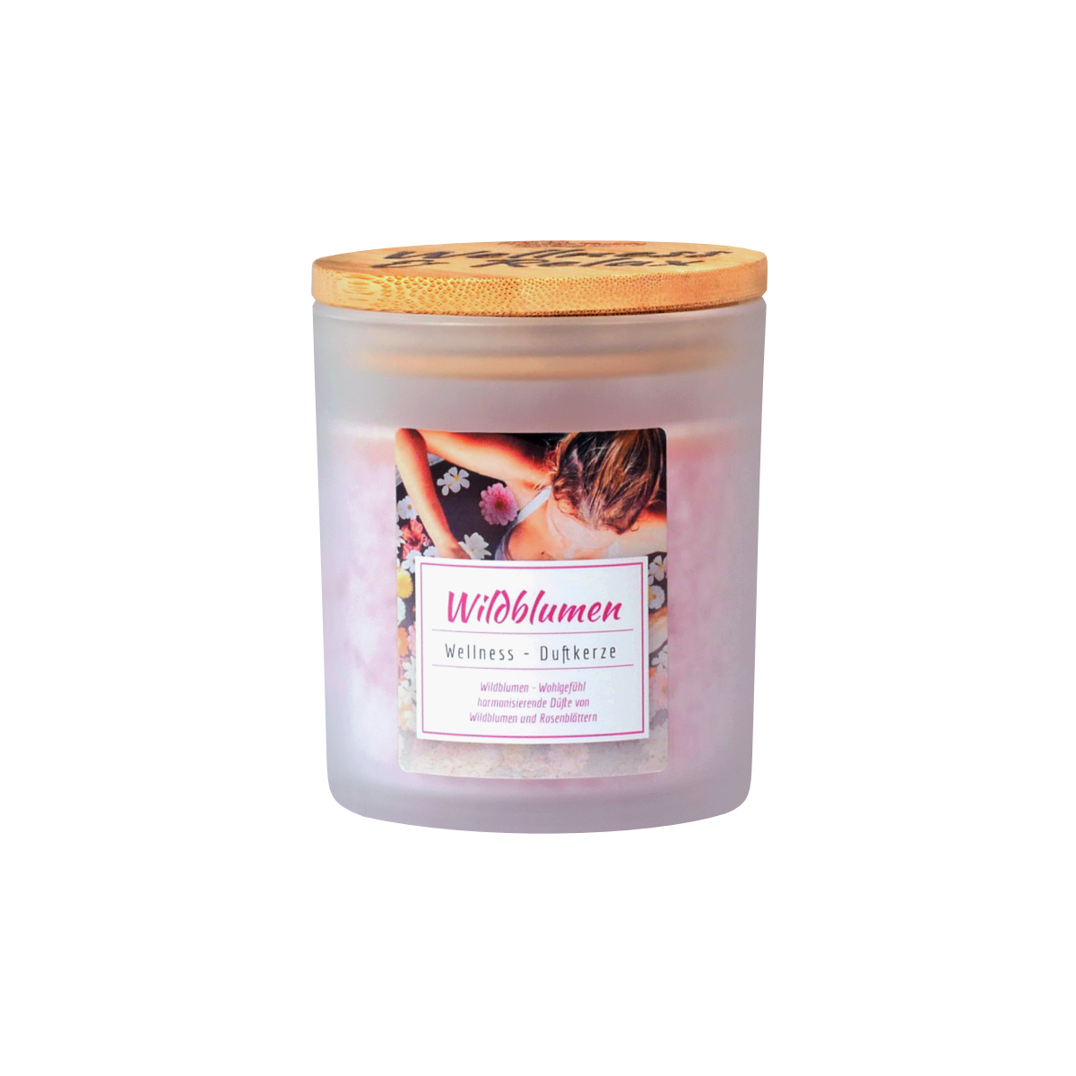 Die Candle Factory Wellness-Duftkerze Wildblumen ist eine Kerze in einem Milchglas mit Holzdeckel. Das Etikett zeigt eine Frau inmitten von Blumen und einen deutschen Text über Stearin, Wellness-Duftkerzen und von der Natur inspirierte Düfte.