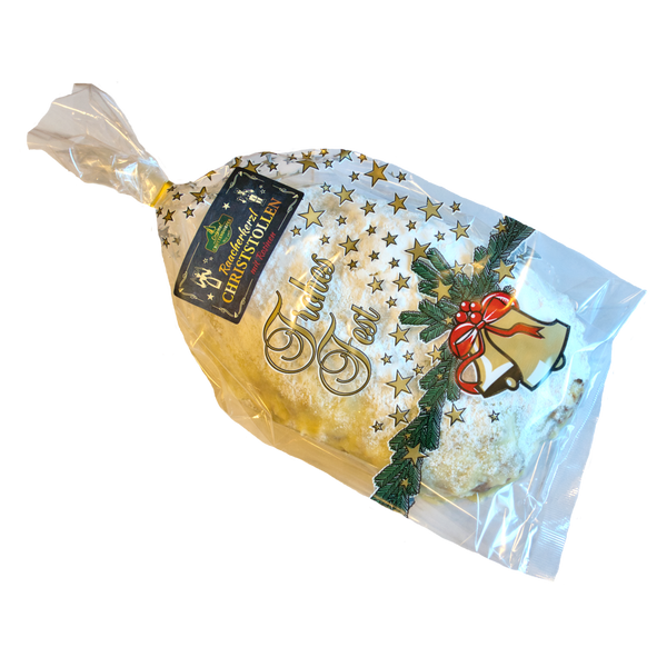 Ein Laib Raacherkerzl-Christstollen mit Rosinen von Original Crottendorfer in festlicher Klarsichtverpackung mit Sternen, Stechpalme und roter Schleifenglocke. Das Etikett hebt ausgewählte Zutaten für einen authentischen Geschmack hervor.