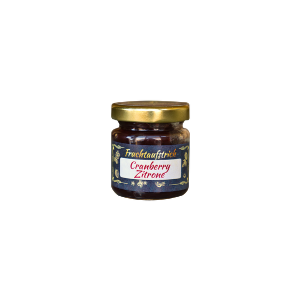 Ein kleines Glas mit goldenem Deckel enthält Original Crottendorfer Hausgemachter Fruchtaufstrich 50 g (Cranberry Zitrone). Das vegane, laktosefreie Etikett zeigt Fruchtabbildungen auf dunklem Hintergrund.