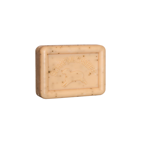 Das rechteckige, beigefarbene Seifenstück Ovis Schafmilchseife Küchenseife mit dem Schriftzug „SCHAFMILCHSEIFE“ und einem Schafs-Umriss ist mit Schafmilch angereichert. Es hat eine glatte Oberfläche mit kleinen dunklen Sprenkeln.