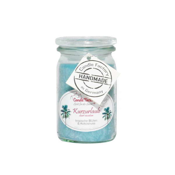 Die Candle Factory Duftkerze/Windlicht "Kurzurlaub" Baby-Jumbo ist ein Glasgefäß mit hellblauem Wachs und Palmengrafik. Ein rundes "Handmade in Germany" Etikett ist angebracht. Der Duft ist eine Mischung aus tropischen Blüten und Kokosnuss. Vor einem weißen Hintergrund.