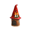 Ein verspieltes „Räucherhaus“-Keramik-Minizipfelhaus von Original Crottendorfer, liebevoll gefertigt, mit einem hohen roten Dach, kleinen Fenstern, einer Holztür und zwei orangefarbenen Pilzen, die aus dem Dach wachsen.