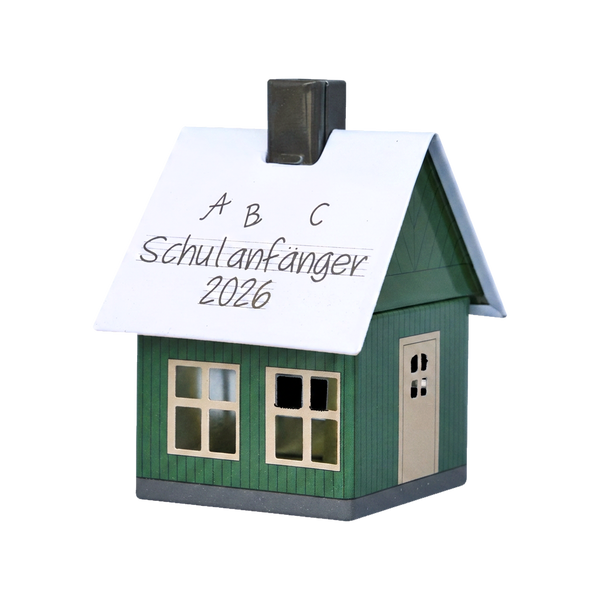 Ein kleines grünes „Räucherhäuschen Schulanfänger 2026“ von Original Crottendorfer mit weißem Dach, auf dem mit schwarzem Filzstift „A B C Schulanfänger 2026“ geschrieben steht.