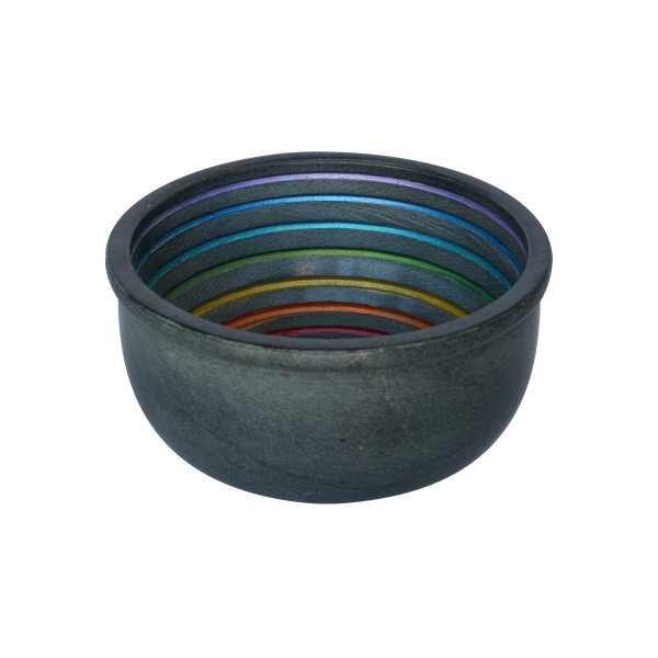 Die Plantaroma Räucherschale Jannis ist eine dunkle, runde Räucherschale mit einer matten Außenseite und einer glatten Innenseite, die mit regenbogenfarbenen konzentrischen Ringen verziert ist, die auf einem schlichten weißen Hintergrund dargestellt sind.
