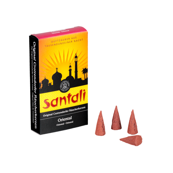 Eine Schachtel mit Räucherkerzen Oriental, an deren Außenseite drei rote Räucherkerzen angebracht sind, zeigt eine östliche Skyline-Silhouette auf einem orange-gelben Farbverlauf. Der deutsche Text von Original Crottendorfer Räucherkerzen beschreibt es als orientalische Note Weihrauch.