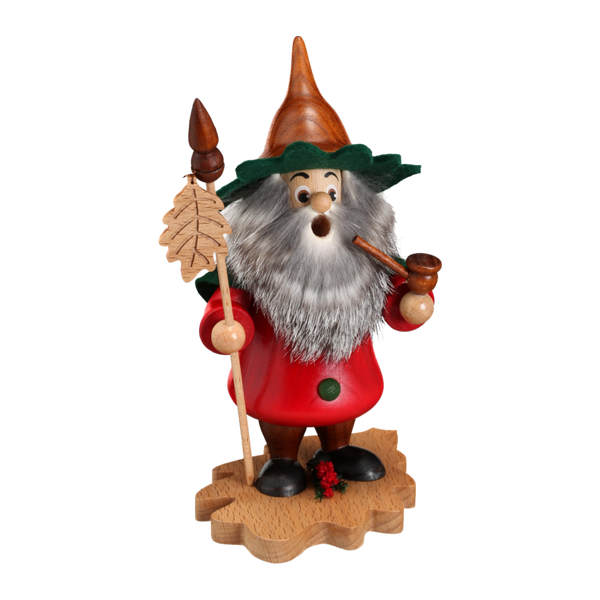Das Blattwichtel Eichenblatt von DWU Drechselwerkstatt Uhlig ist ein bezaubernder Räuchermann aus Holz. Dieser bärtige Gnom, geschmückt mit einem roten Mantel, einem grünen Hut und braunen Stiefeln, hält eine Pfeife und einen Stab mit einer Tannenspitze und steht auf einem blattförmigen Sockel. Ein wahres Stück Volkskunst!.