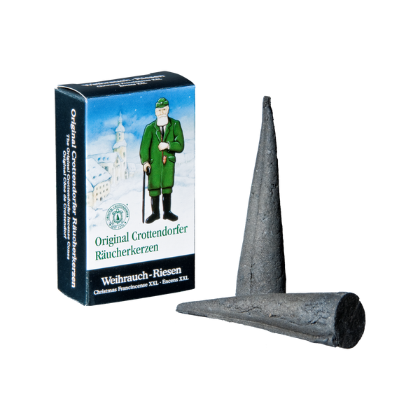 Die Original Crottendorfer Räucherkerzen Riesen 4er enthalten eine Box mit Trachtenillustrationen, perfekt für Räuchermänner-Fans, und zwei große, dunkelgraue Räucherkegel, die sich ideal zum Füllen großer Räume mit ihrem betörenden Duft eignen.