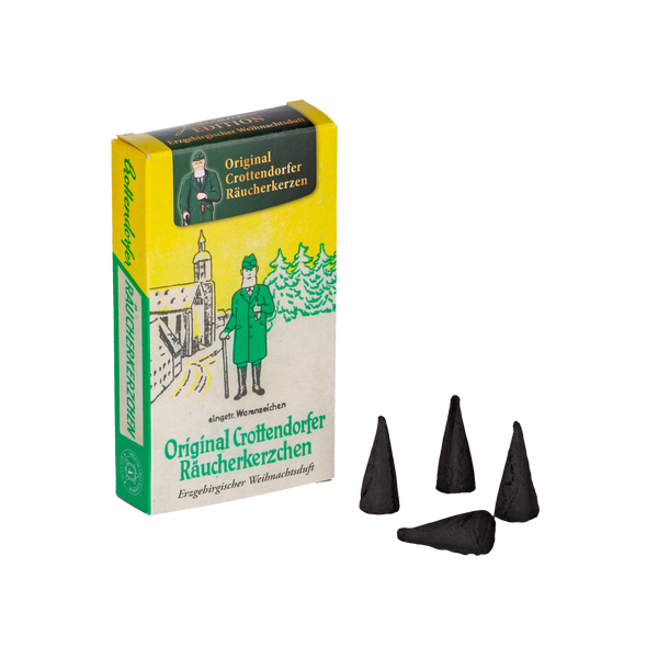 Die Räucherkerzen Jubiläums Edition Erzgebirgischer Weihnachtsduft von Original Crottendorfer zeigt ein Vintage-Design eines Mannes in Grün vor einem Gebäude und enthält vier schwarze Weihrauchkegel, ideal, um Ihren Weihnachtslandschaften ein reiches Aroma zu verleihen.