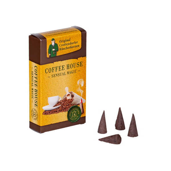 Eine braune Schachtel „Räucherkerzen Kaffeehaus“ von Original Crottendorfer Räucherkerzen, dekoriert mit Kaffeebohnen und einer dampfenden Tasse, lädt zu einer Duftreise ein. Vier dunkelbraune Räucherkerzen daneben erinnern an die traditionelle Essenz der Kaffeehäuser.