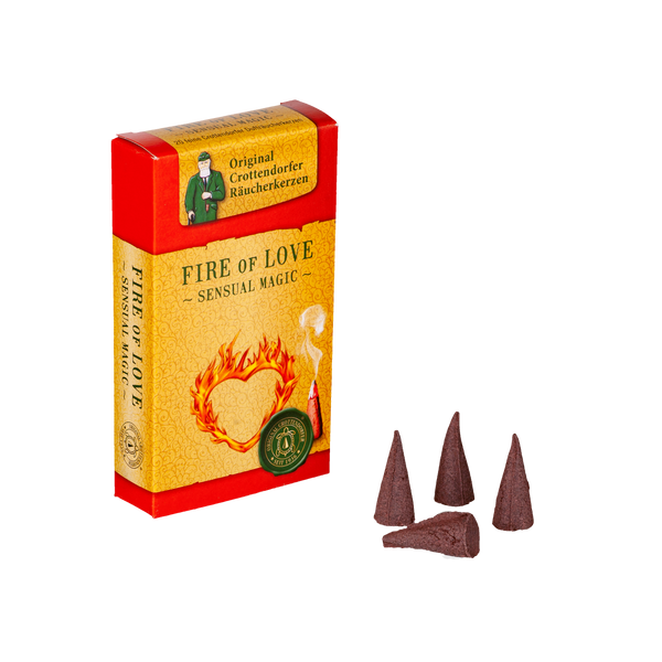 Eine rot-gelbe Schachtel mit der Aufschrift „Räucherkerzen Feuer der Liebe“ von Original Crottendorfer Räucherkerzen zeigt eine Flammengrafik und ein Emblem, in deren Nähe vier braune Zapfen einen betörenden Duft von Vanille und Jasmin verströmen und an einen blühenden Blumengarten erinnern.