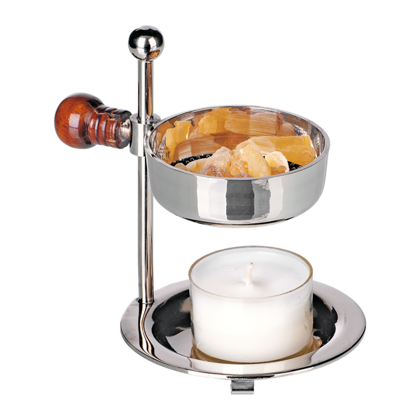 Der Weihrauchbrenner aus Messing vernickelt von Original Crottendorfer Räucherkerzen besticht durch sein elegantes, reflektierendes Silberdesign mit Holzgriff, Schale für goldenes Harz und Platz für ein Teelicht. Er ist höhenverstellbar und passt sich so perfekt Ihren aromatischen Bedürfnissen an.