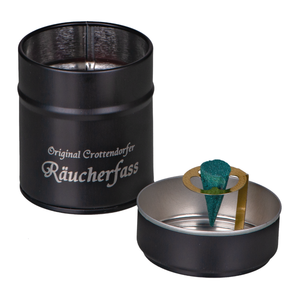 Ein schwarzer, zylindrischer Räucherhalter, der einer Blechdose ohne Deckel ähnelt, zeigt einen grünen Kegel auf einem Metallsockel. Er trägt in weißer Schrift die Aufschrift „Original Crottendorfer Räucherkerzen – Crottendorfer Räucherfass zimt“ und verspricht ein exquisites Räuchervergnügen.