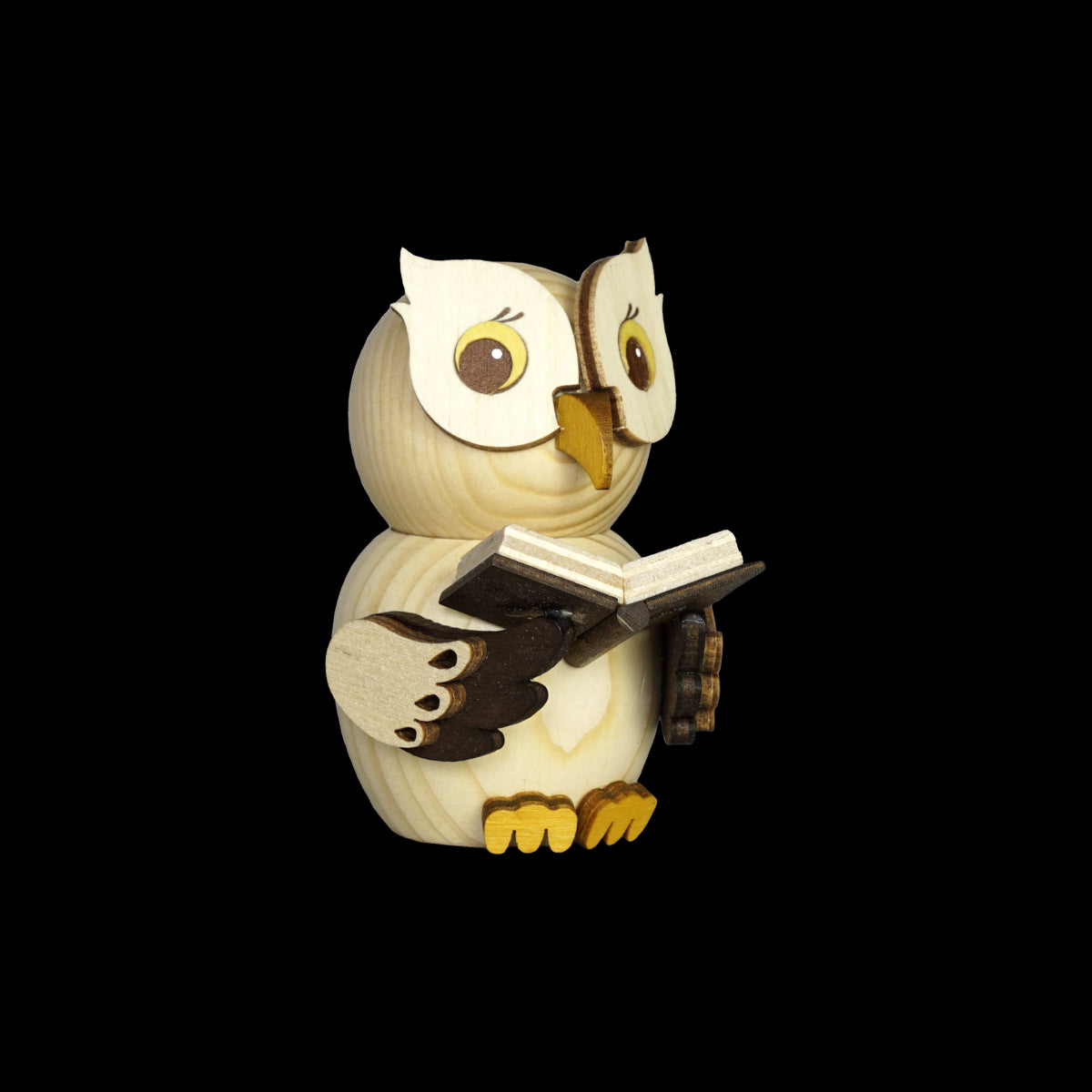 Die Mini Eule mit Buch von Drechslerei Kuhnert ist eine Holzfigur aus hellen und dunklen Holzstücken. Mit ihrem ausdrucksstarken Gesicht und den großen Augen hebt sich die Eule vom schwarzen Hintergrund ab und zeigt filigrane Details und ein Bekenntnis zur Nachhaltigkeit.