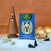 Eine Schachtel „Räucherkerzen Nostalgie Edition Weihnachtszauber“ von Original Crottendorfer Räucherkerzen steht auf einer verschneiten Oberfläche, umgeben von Goldornamenten, schwarzen Räucherkegeln und Sternen. Im Hintergrund steht eine hölzerne Kegelfigur, die ein tabakartiges Aroma mit balsamisch-süßlichem Duft verströmt.