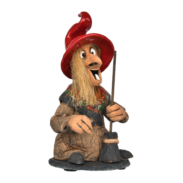 Die limitierte Auflage der Räucherhexe - Rot, mit Schieferteller von Original Crottendorfer ist eine skurrile Figur, die eine fröhliche Hexe im Schneidersitz darstellt. Sie trägt einen leuchtend roten Hut, einen strukturierten braunen Umhang, hat strohartiges Haar und hält einen kleinen Besenstiel.